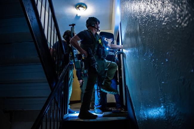 Deputy U.S. Marshals gaining entry into a residence during…