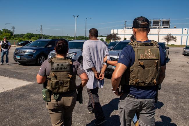 Deputy U.S. Marshals with captured fugitive during…