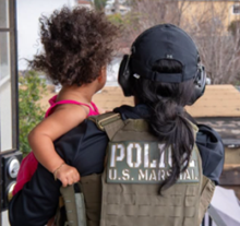 Deputy U.S. Marshal holding child